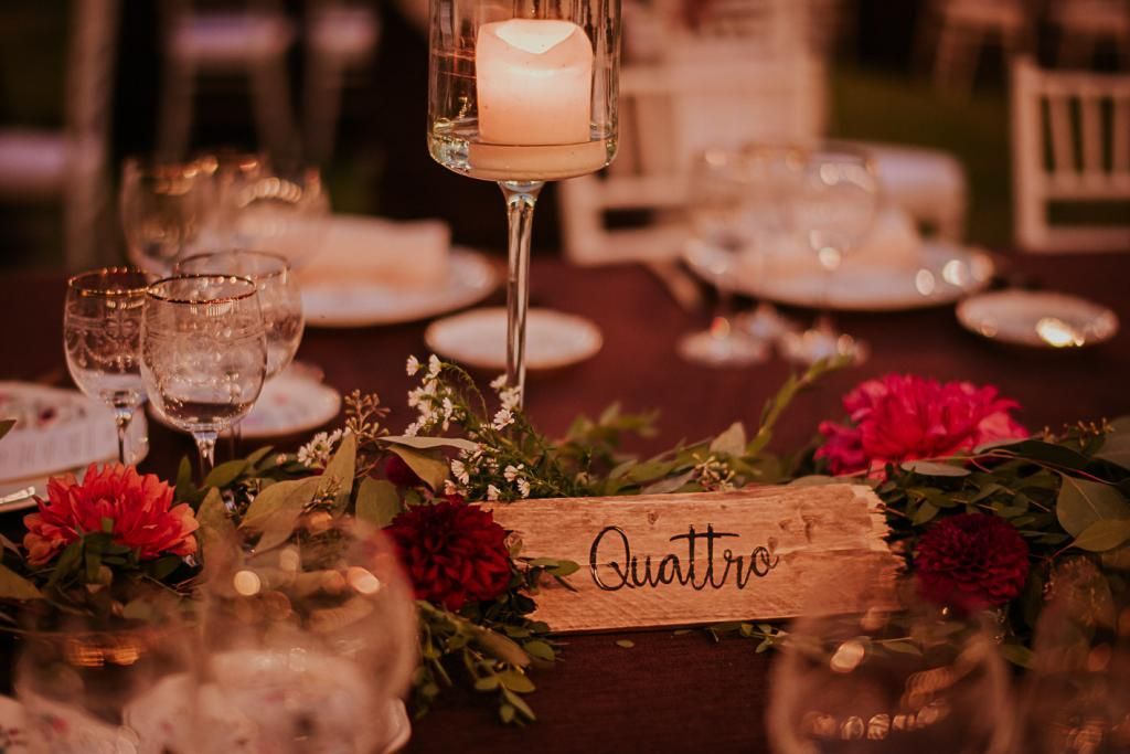 Un tavolo con sopra una candela e dei fiori.