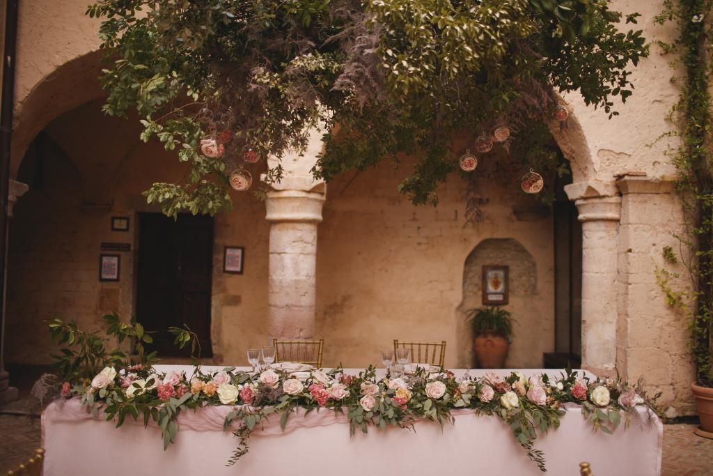 Un tavolo con fiori sopra davanti a un edificio