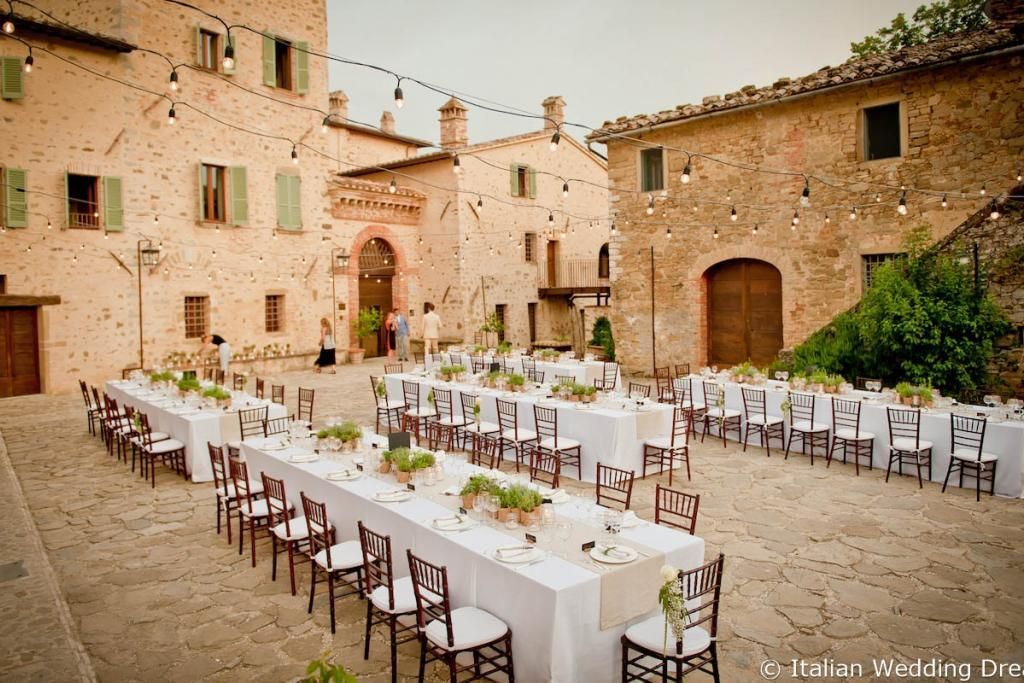 Un tavolo molto lungo con sedie davanti a un edificio.