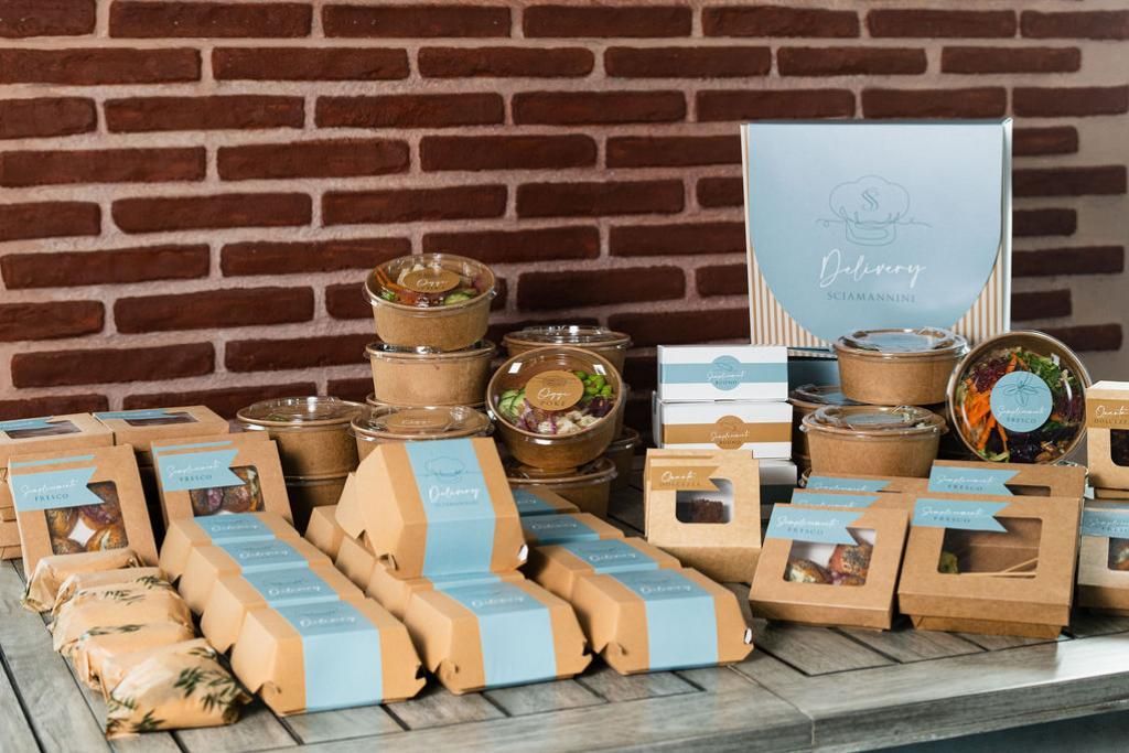 Un tavolo di legno sormontato da scatole di cibo e un muro di mattoni sullo sfondo.