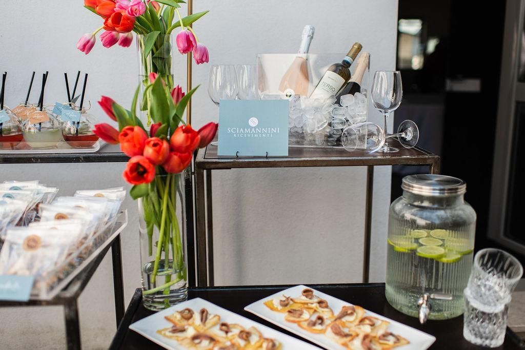 Un tavolo con piatti di cibo e sopra un vaso di fiori.