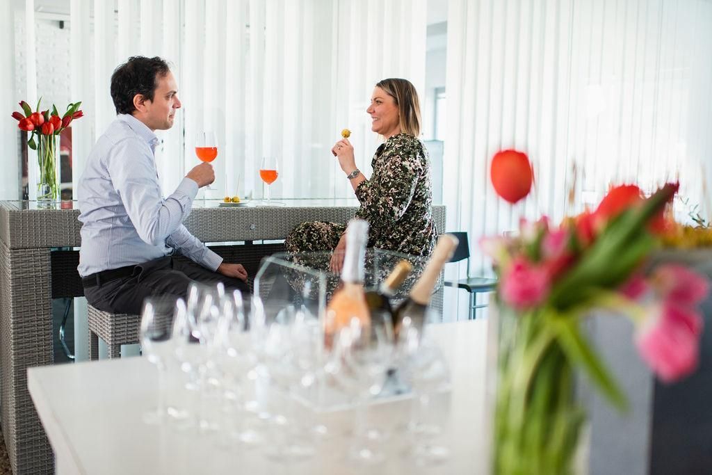 Un uomo e una donna sono seduti a un tavolo e bevono vino.