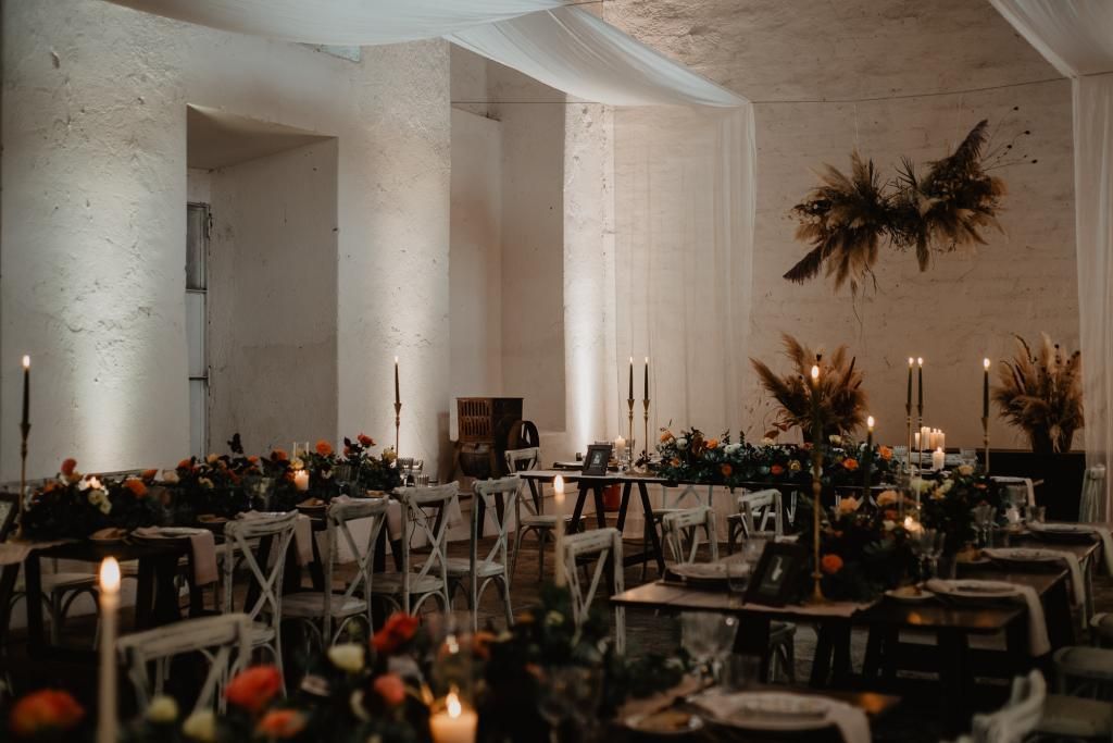 Una grande stanza piena di tavoli, sedie e candele.