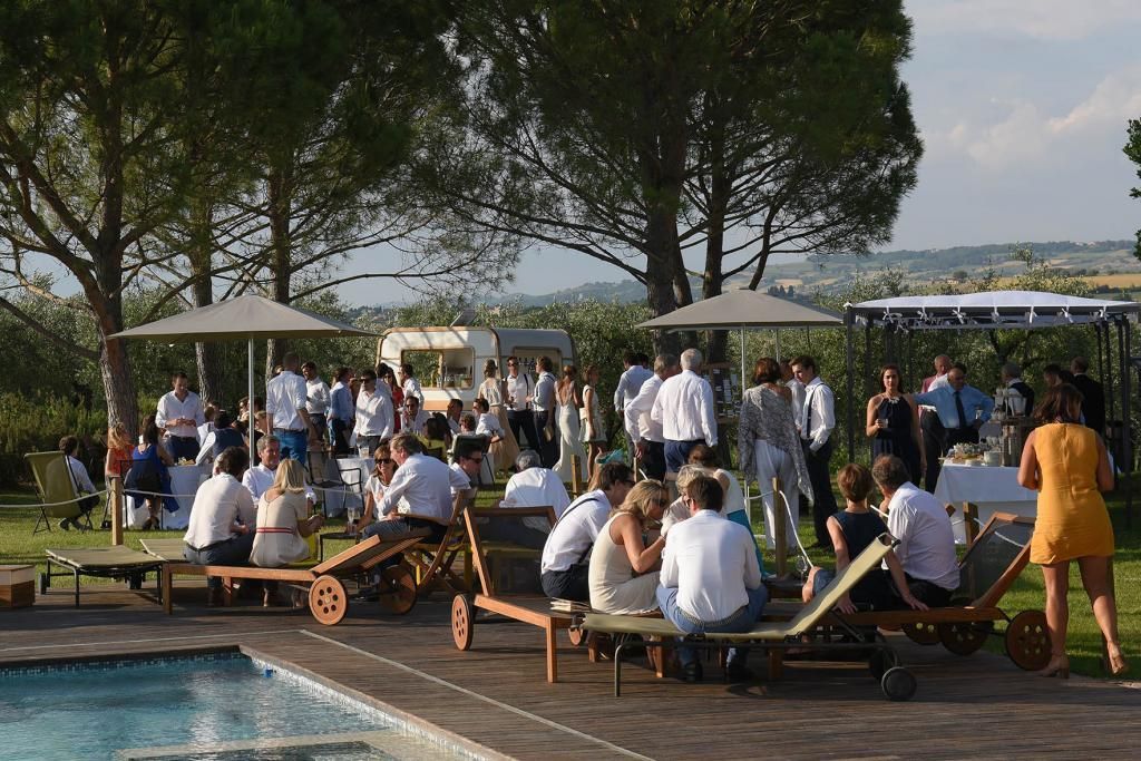 Un gruppo di persone è raccolto attorno ad una piscina.
