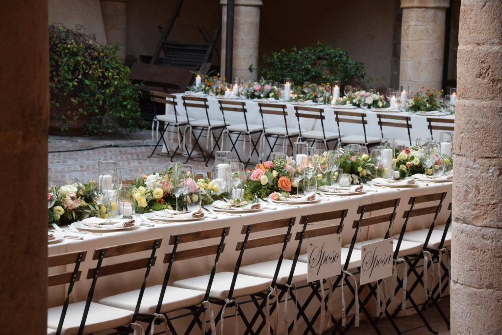 Un lungo tavolo con sedie e fiori sopra
