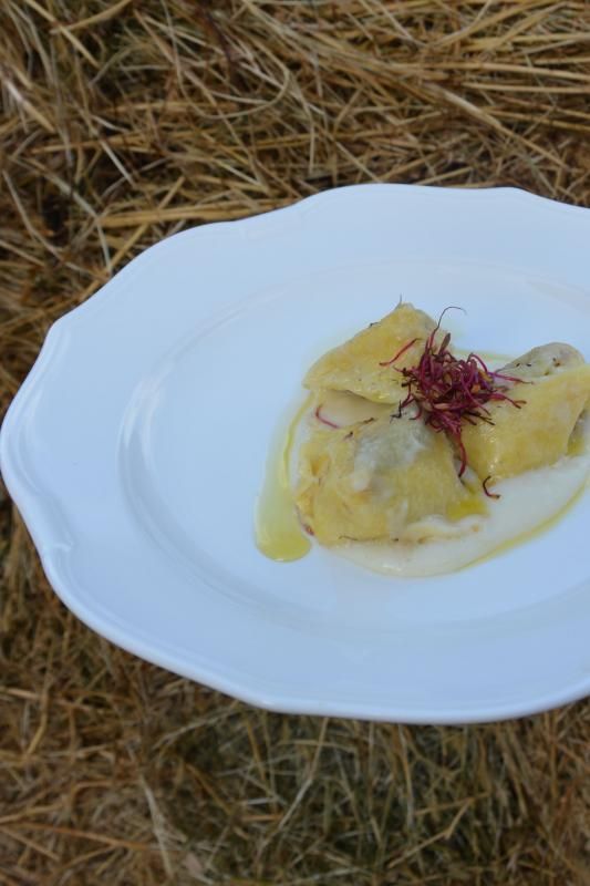 Un piatto bianco sormontato da un pezzo di cibo è seduto sopra un mucchio di fieno.