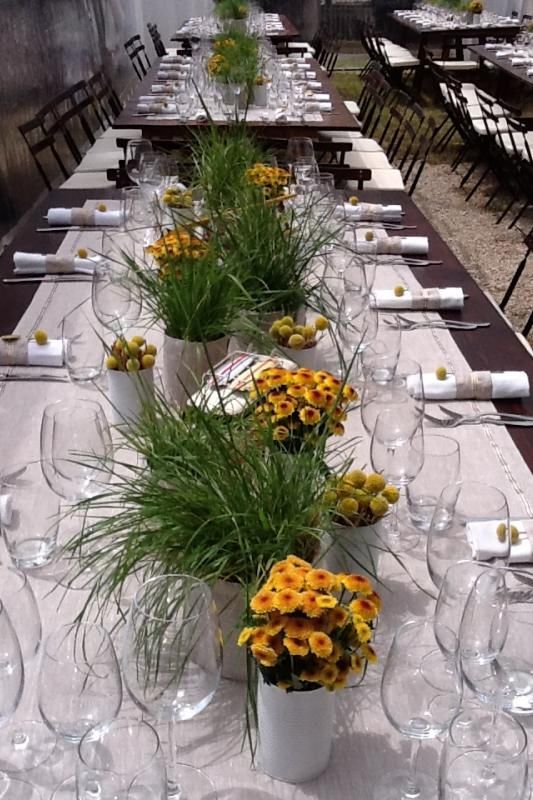 Un lungo tavolo con fiori e bicchieri di vino sopra