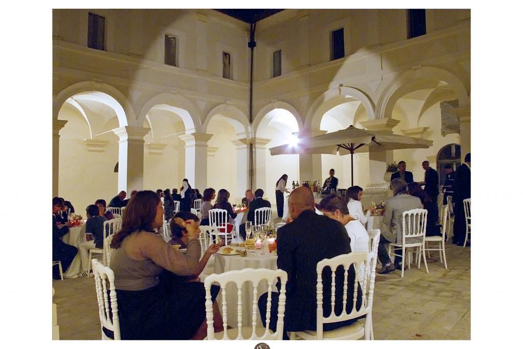 Un gruppo di persone è seduto ai tavoli in un cortile di notte.