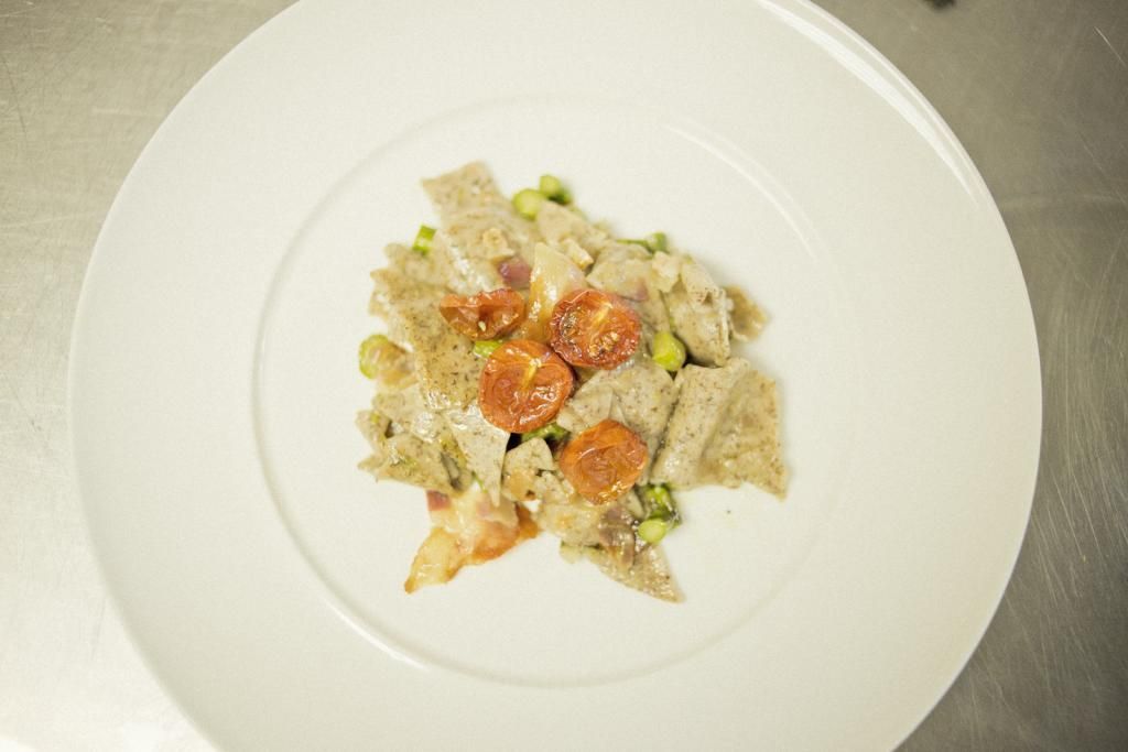 Un piatto bianco condito con un'insalata di carne e verdure.