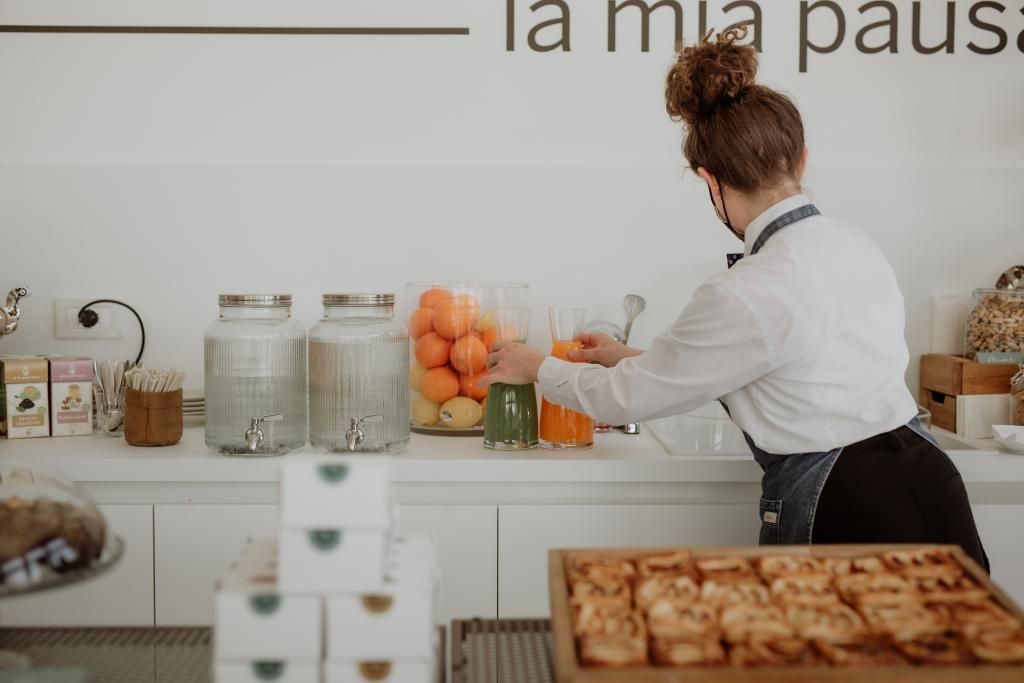 Una donna è in piedi in una cucina che prepara il cibo.