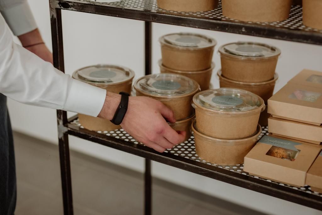 Una persona prende una ciotola di cibo da uno scaffale.