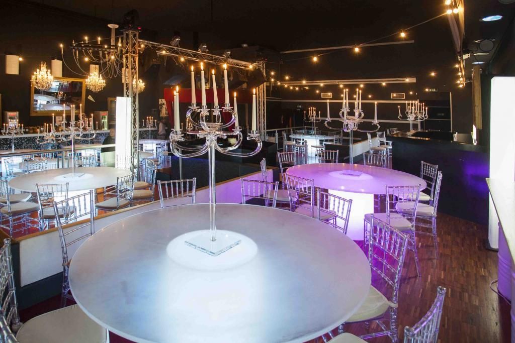 Una grande sala con tavoli e sedie e un lampadario appeso al soffitto.