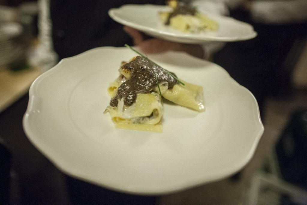 Una persona tiene in mano un piatto bianco con sopra un pezzo di cibo.