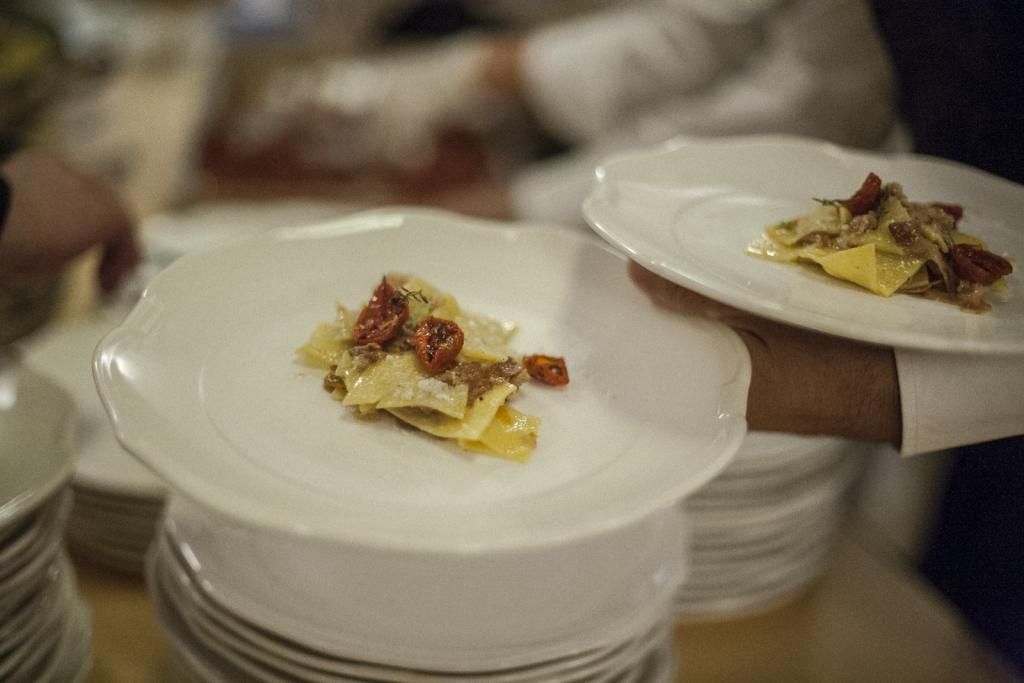 Una persona tiene in mano due piatti di cibo.