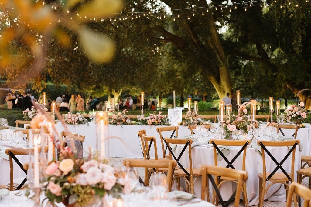 Una fila di tavoli e sedie allestita per un ricevimento di nozze.