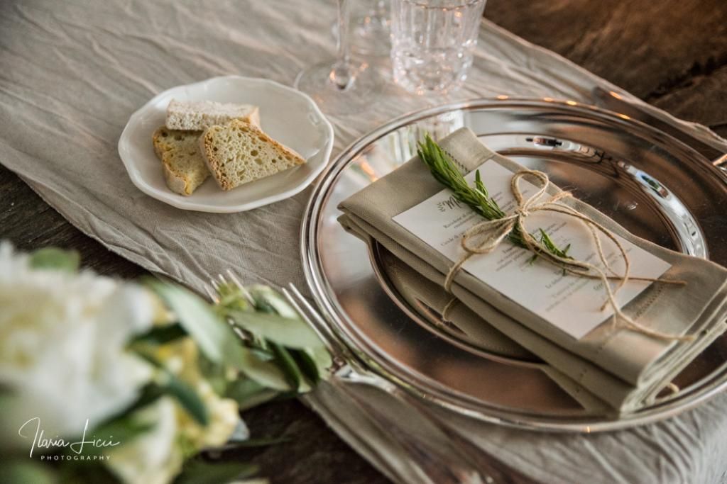 Un piatto d'argento con sopra un tovagliolo e un piatto di pane.