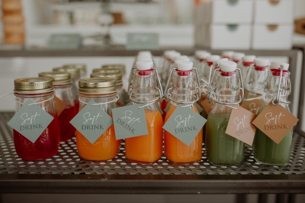 Una fila di barattoli di vetro pieni di diversi tipi di bevande.