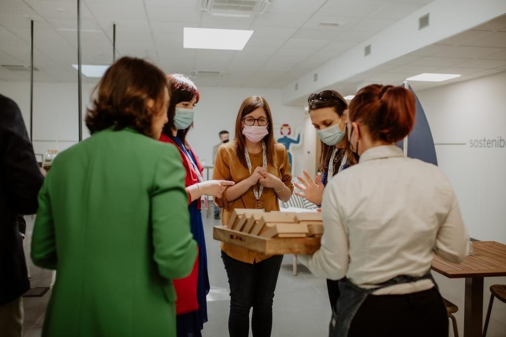 Un gruppo di persone che indossano maschere per il viso sono in piedi in una stanza.
