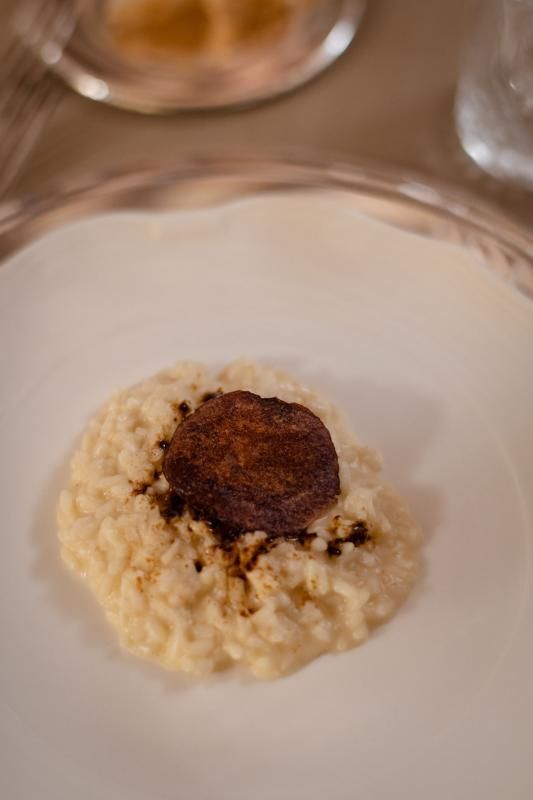 Un piatto bianco condito con riso e un pezzo di carne.