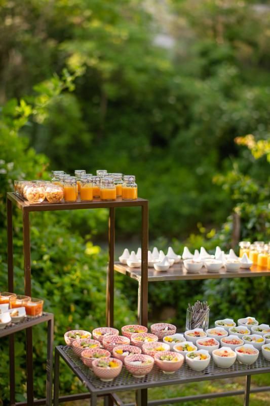 Un tavolo da buffet pieno di ciotole di cibo e bevande.