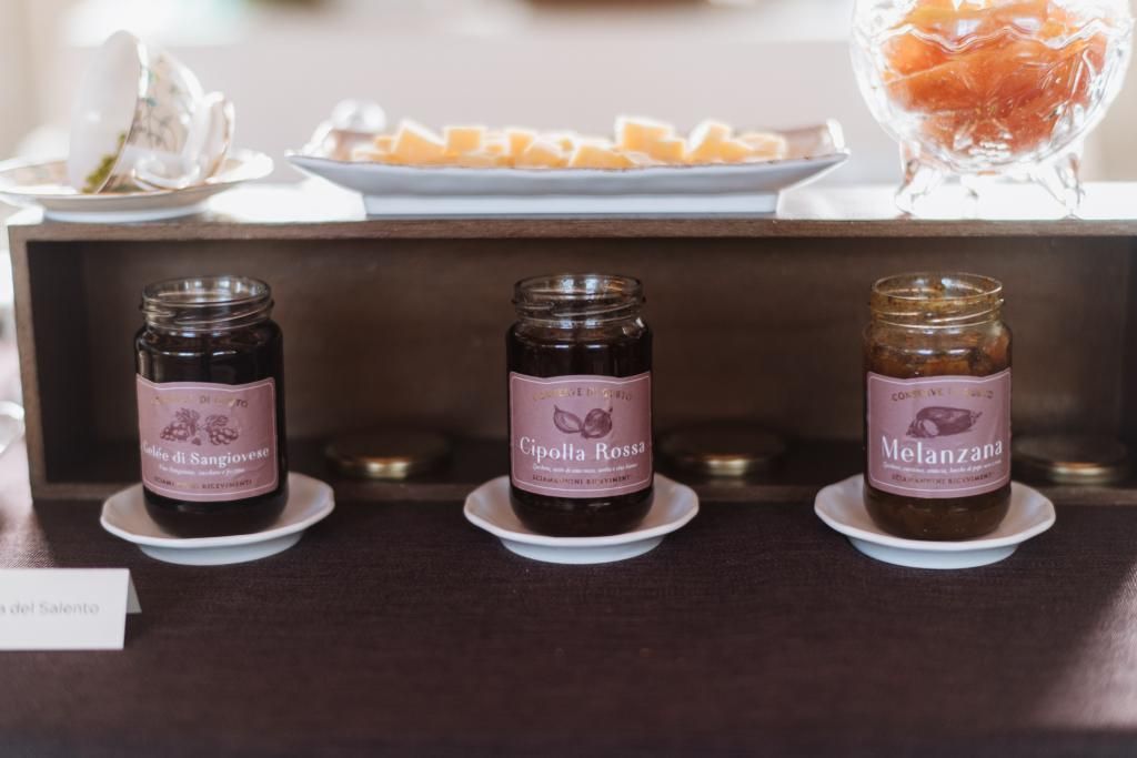 Tre vasetti di marmellata sono posati sui piatti su un tavolo.