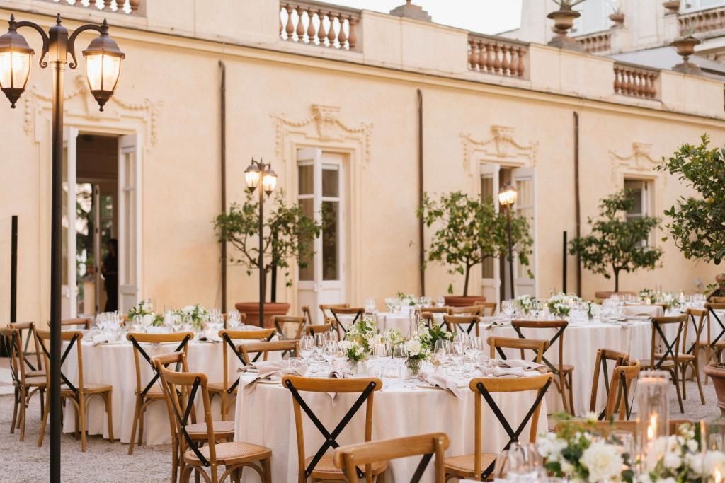 Un grande edificio con tavoli e sedie allestito per un ricevimento di matrimonio.