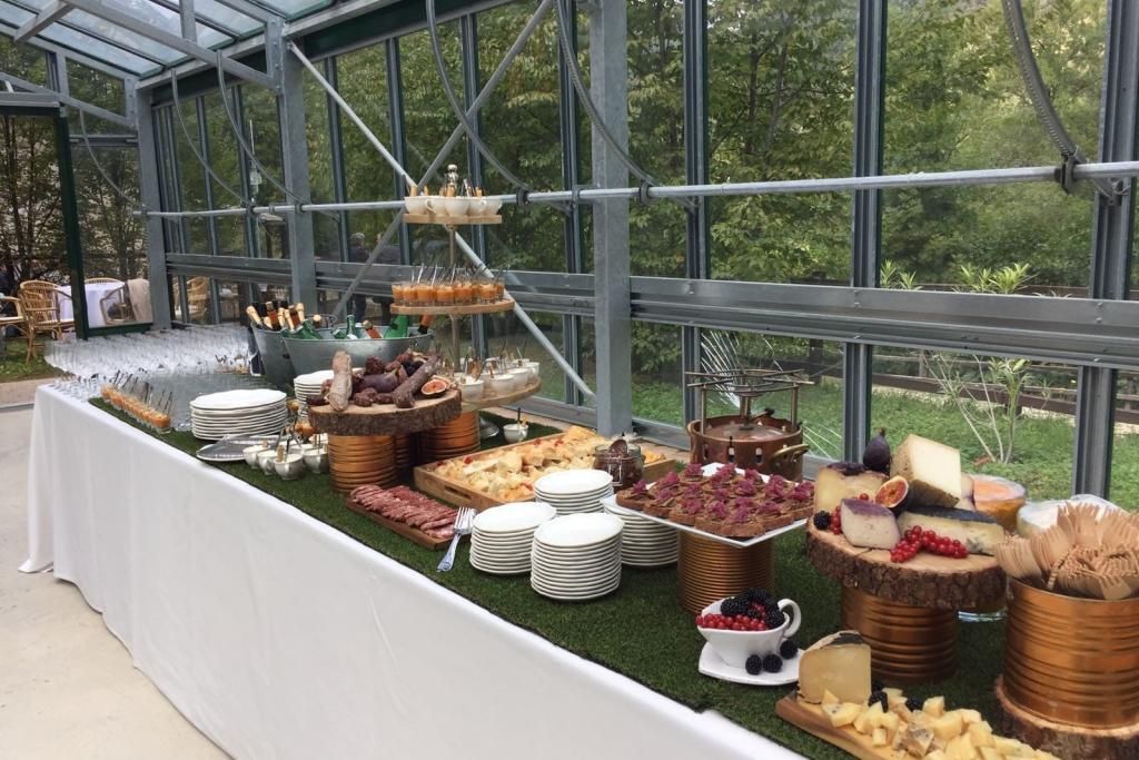 Un lungo tavolo da buffet pieno di cibo in una serra.
