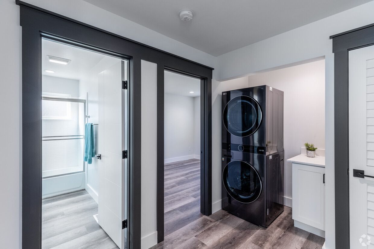 A laundry room with a washer and dryer and a refrigerator.