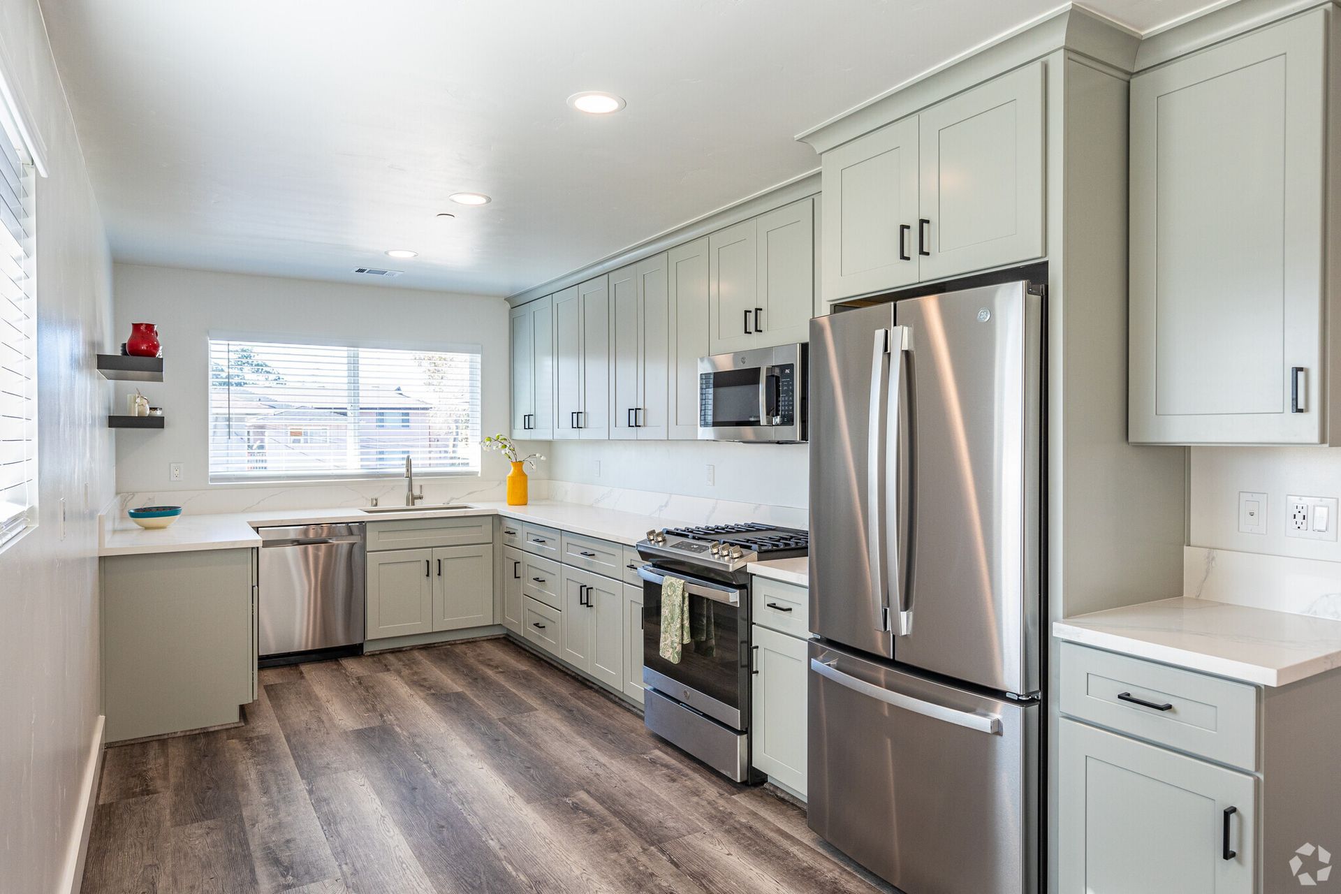 A kitchen with stainless steel appliances and white cabinets.