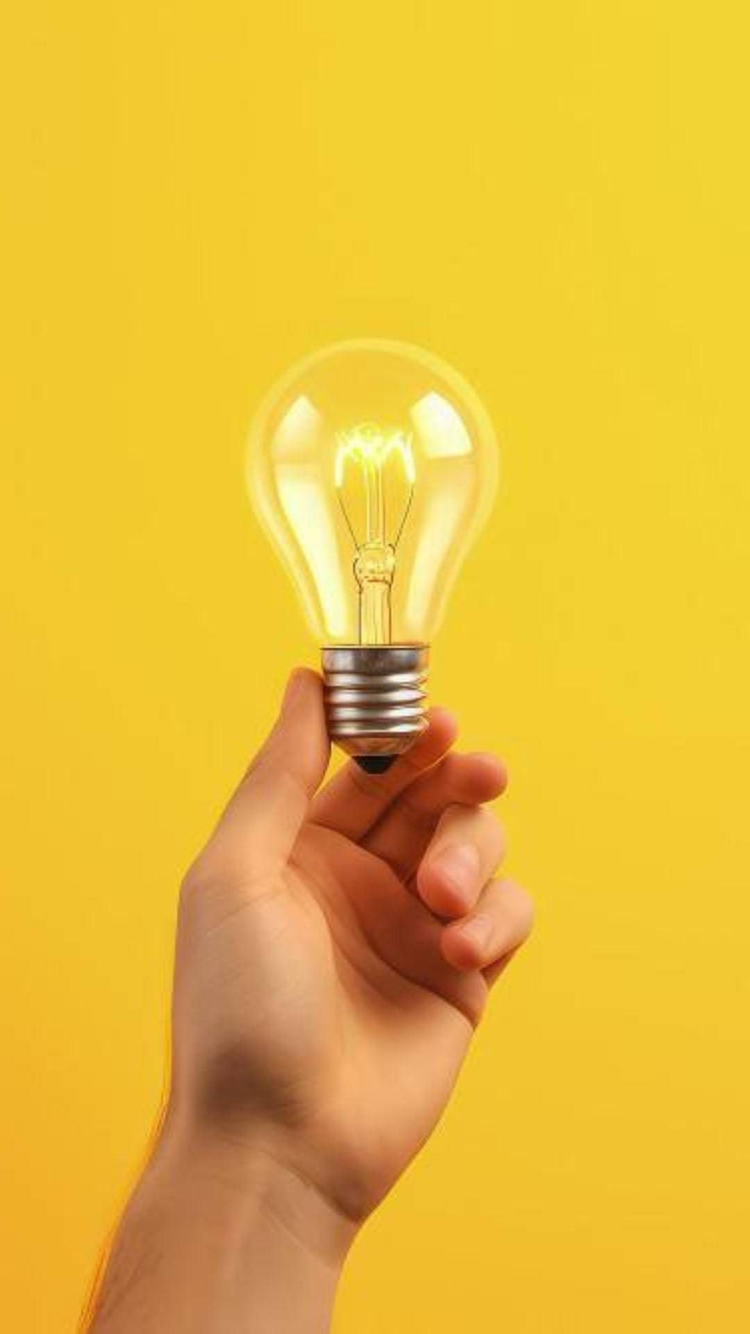A hand holding a light bulb over a yellow background, illustrating the concept of an idea or innovation.