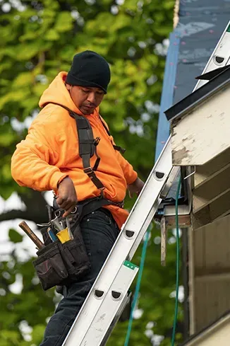 A man is standing on a ladder on top of a building.
