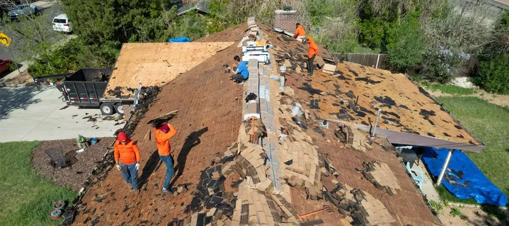 A group of men are working on the roof of a house.