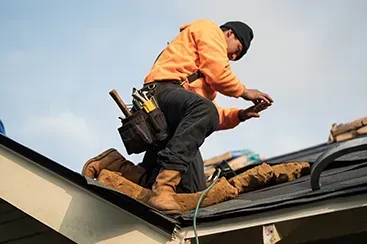 Roofing contractor inspecting shingles after hail damage in Denver, Colorado