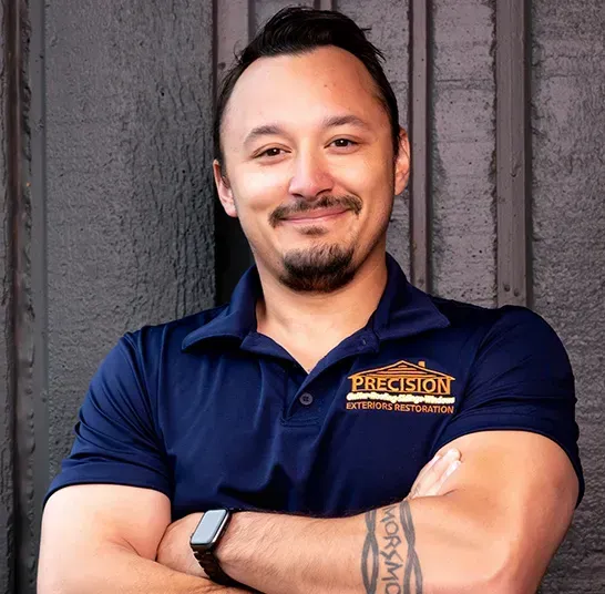 A man wearing a blue shirt with the word precision on it