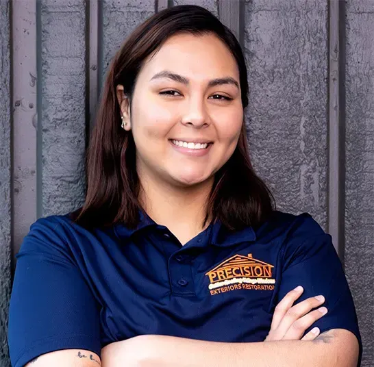 A woman wearing a blue shirt with the word precision on it