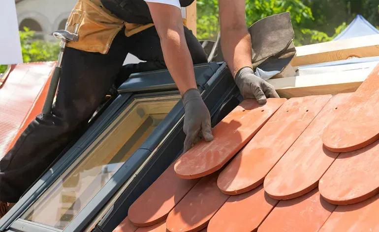 A man is installing a skylight on a roof.
