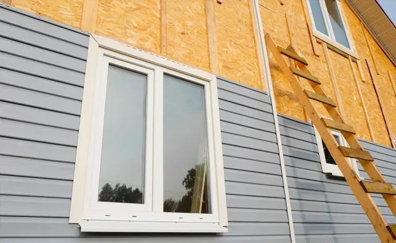 A ladder is attached to the side of a house under construction.