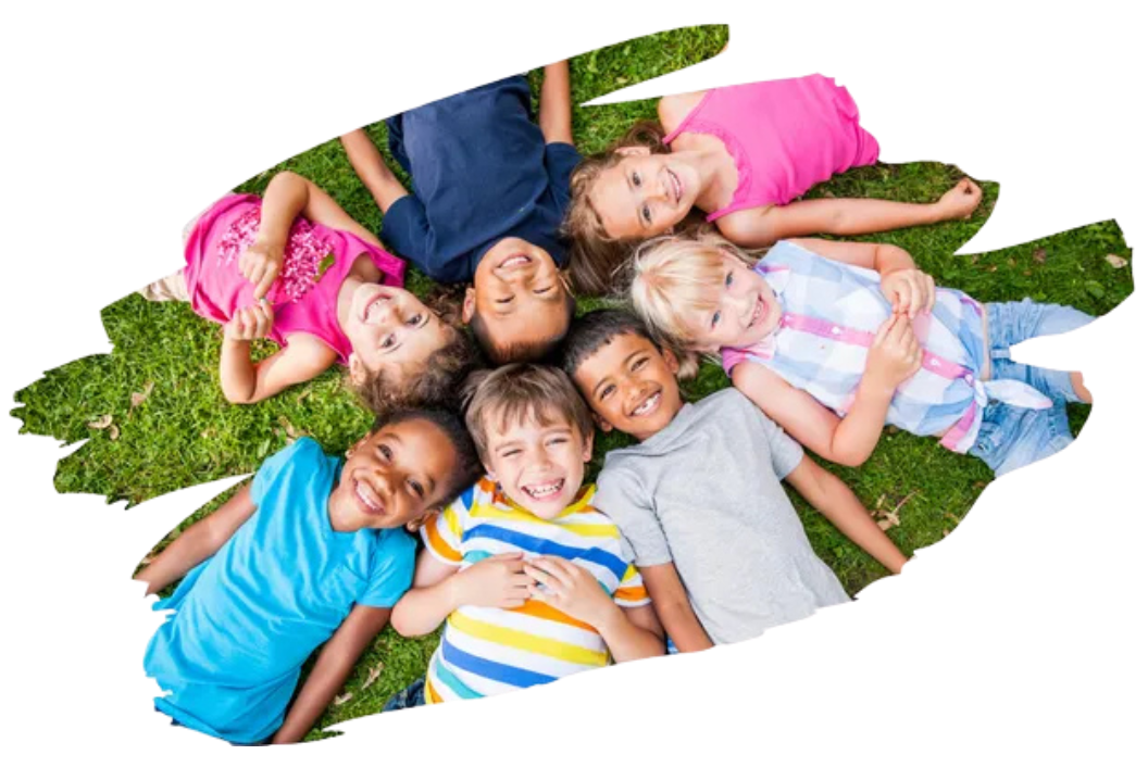 A group of children are laying in a circle on the grass.