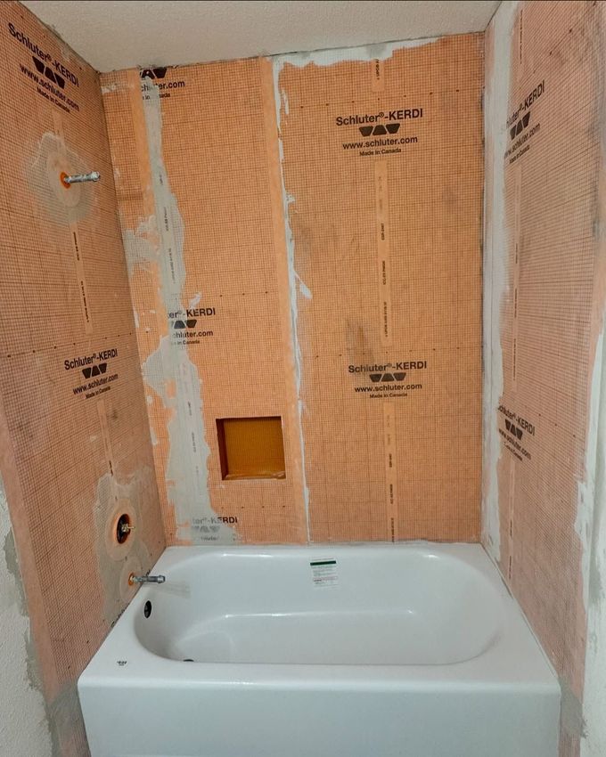 A bathtub is sitting in a bathroom under construction.