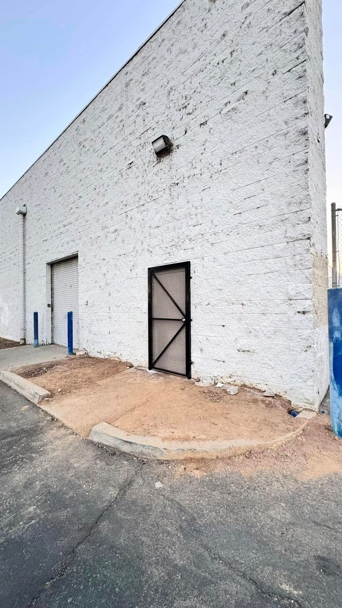 A white building with a black door on the side of it.