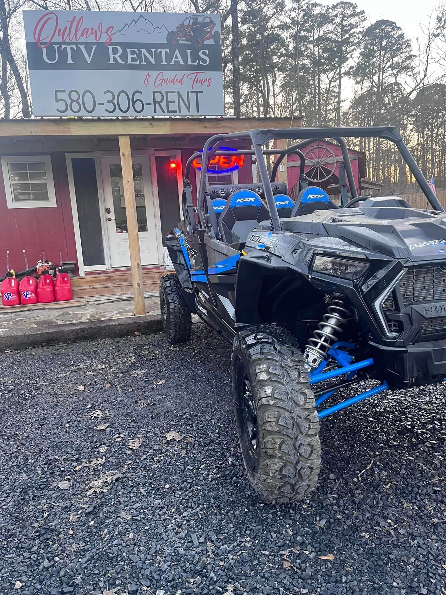 A black and blue atv is parked in front of a building.