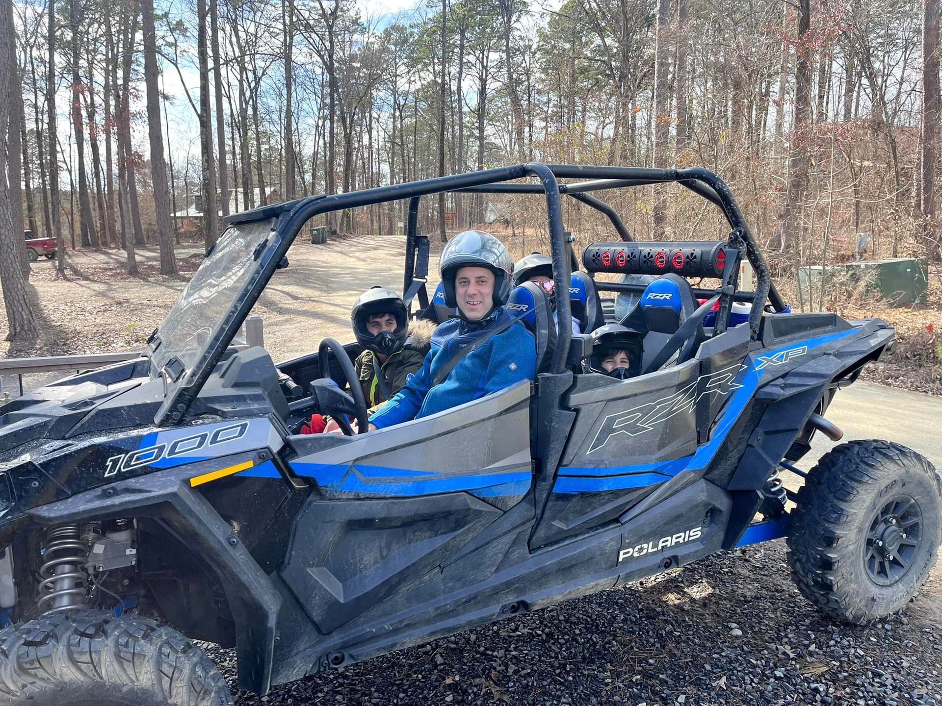 A man is sitting in a atv on a dirt road.