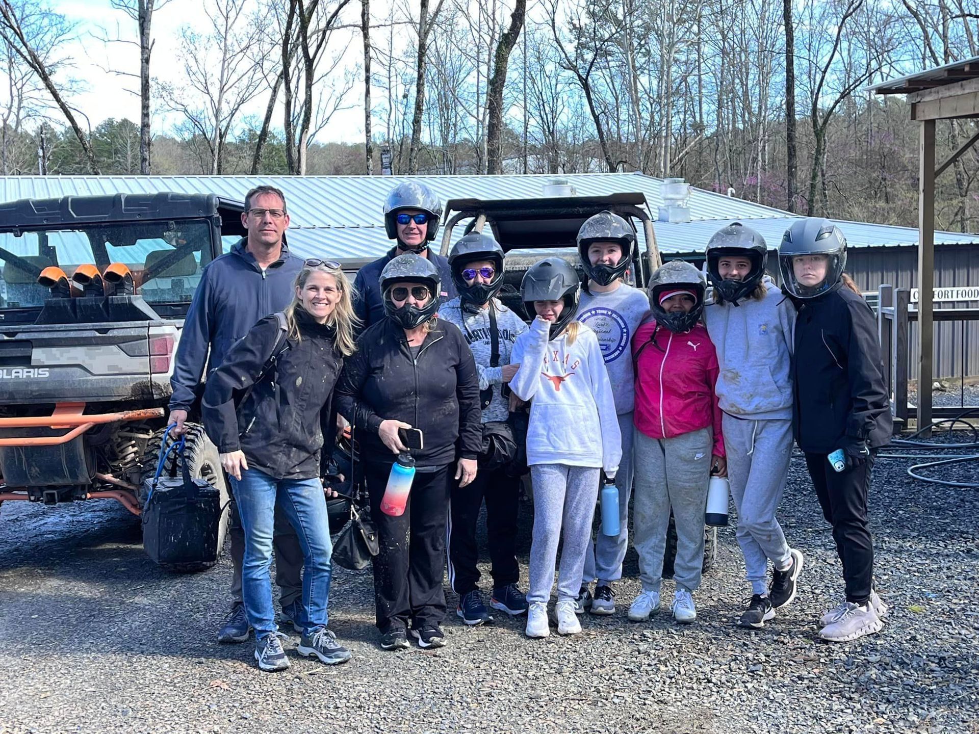 A group of people are posing for a picture in front of a atv.