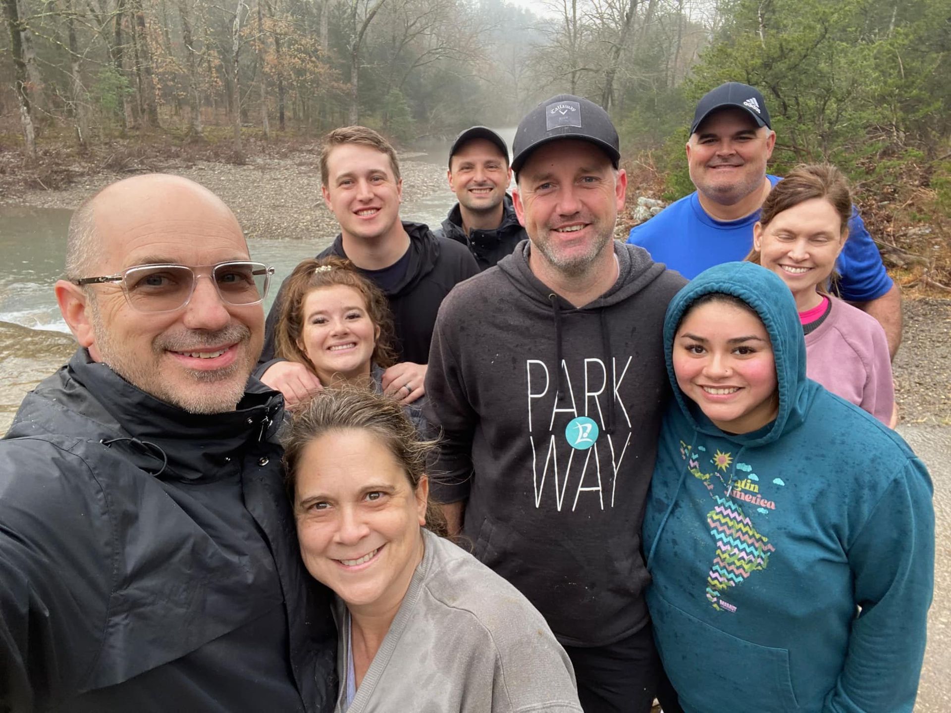 A group of people are posing for a picture in front of a river.