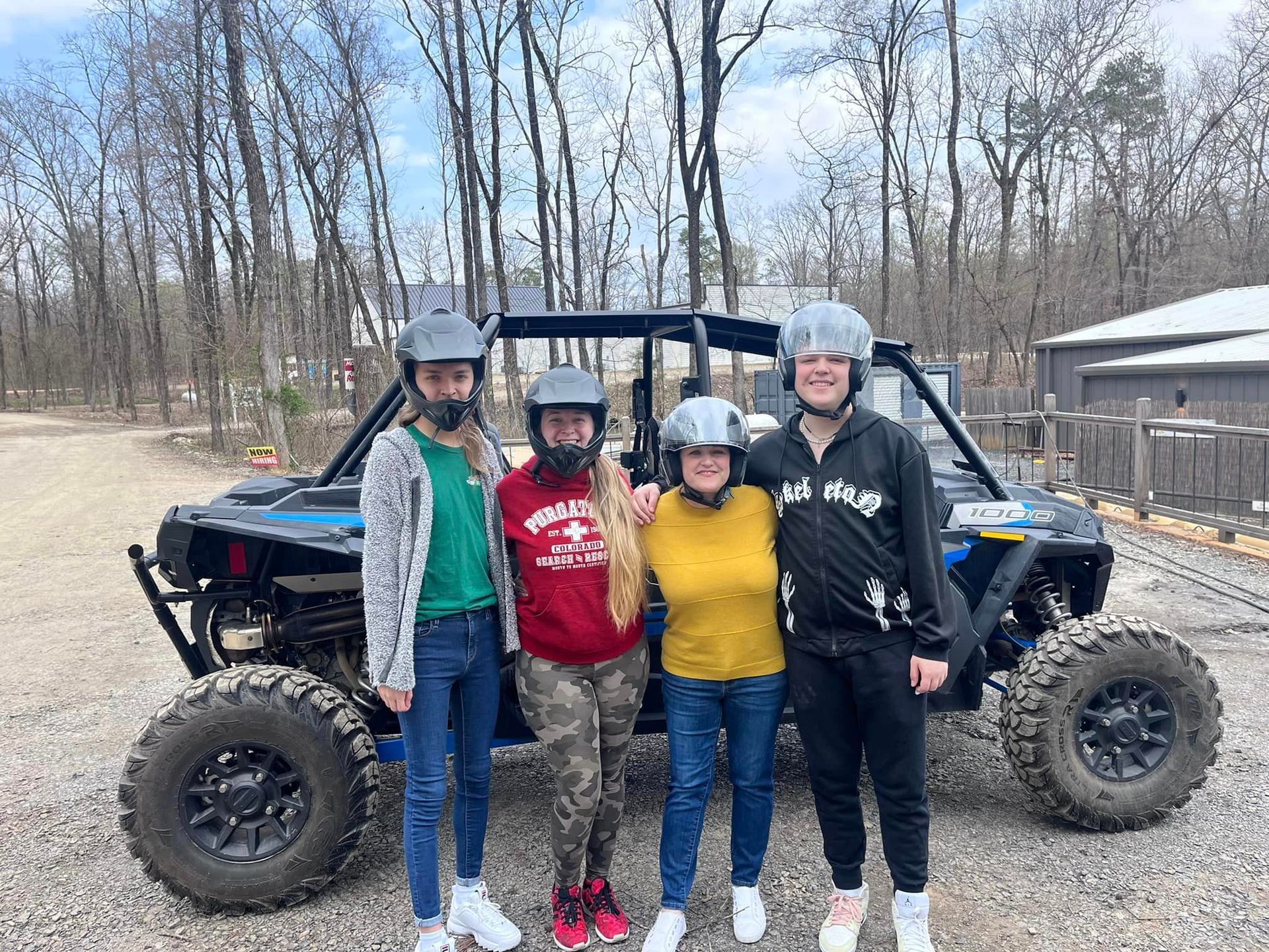 A group of people are posing for a picture in front of a atv.