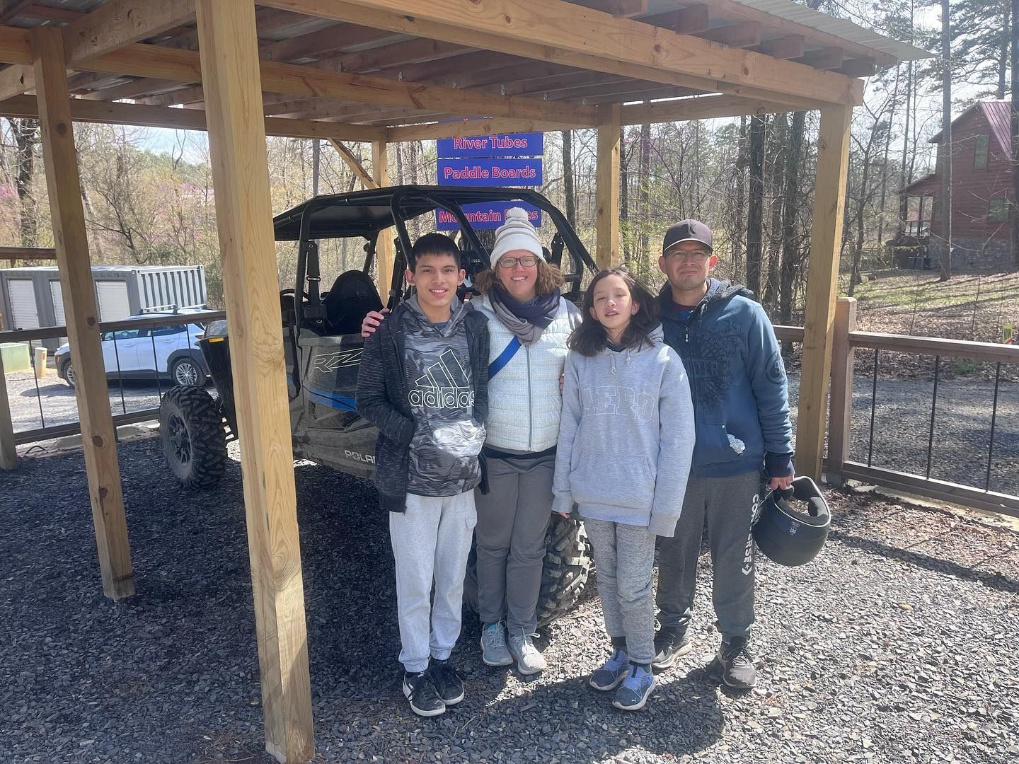 A family is posing for a picture in front of a atv.