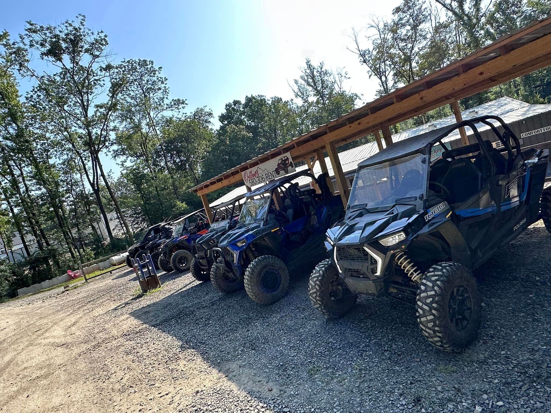 A row of atvs are parked under a covered area.