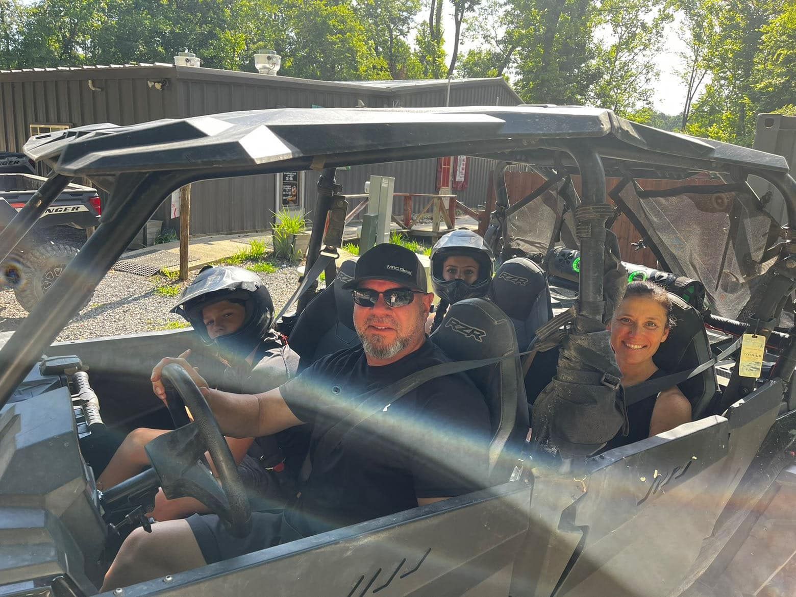 A man and two children are sitting in a atv.