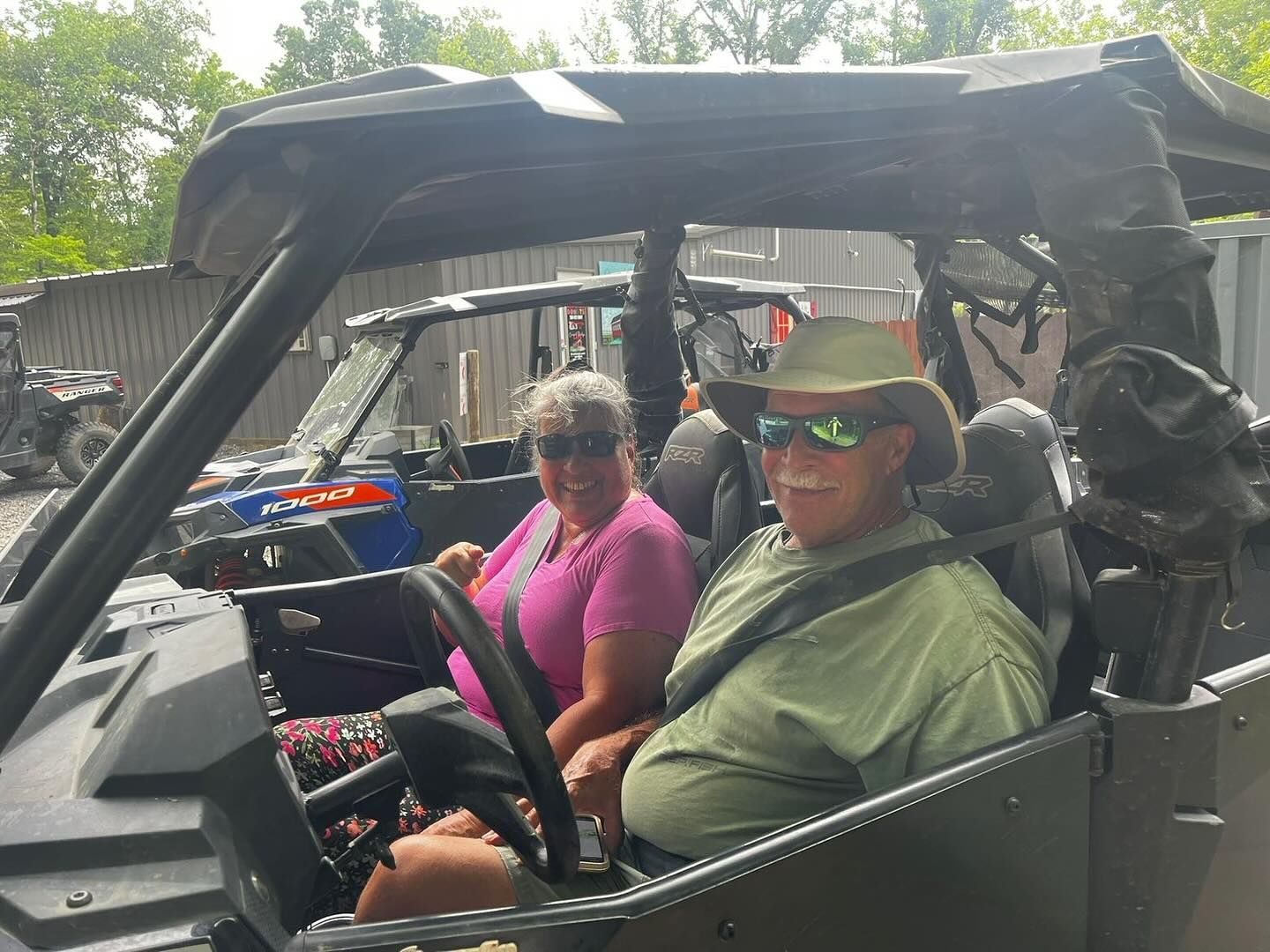 A man and a woman are sitting in a atv.