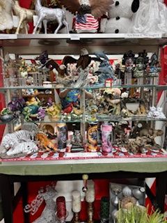 Shelf display filled with various figurines and decor items, featuring eagles and other decorative objects.